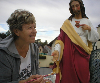 Die restaurierte Jesus-Statue und die zufriedene Künstlerin